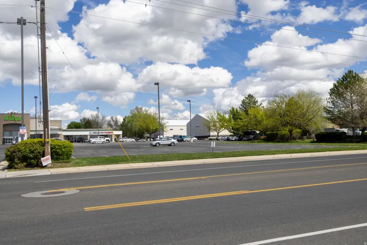 View of asphalt street featuring curbs and sidewalks