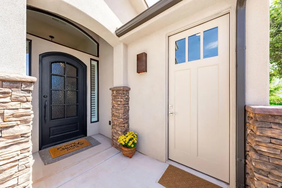 Property entrance featuring stone siding and stucco siding