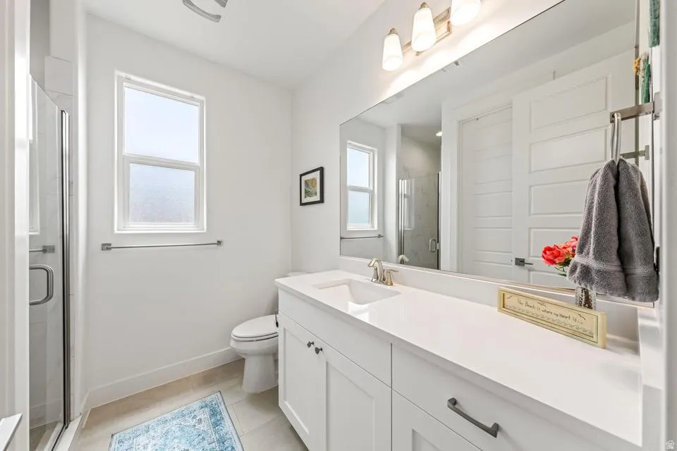 Bathroom with vanity, a shower stall, and light tile patterned flooring