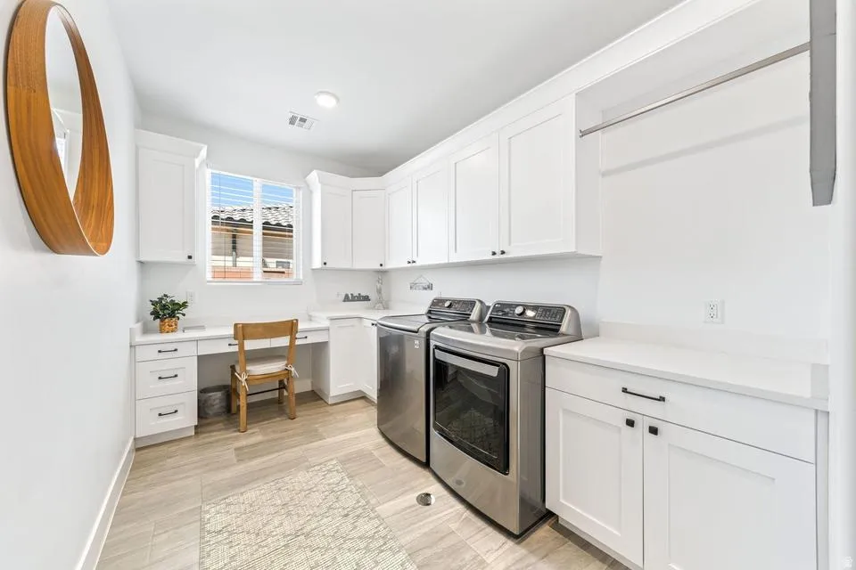 Laundry area with independent washer and dryer, cabinet space, and an office area
