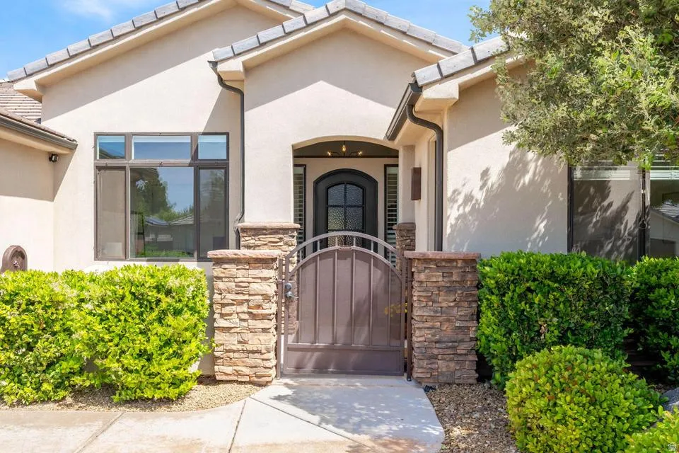 Doorway to property with a gate and stucco siding