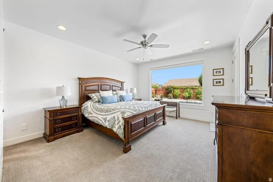 Bedroom featuring light colored carpet, ceiling fan, and recessed lighting