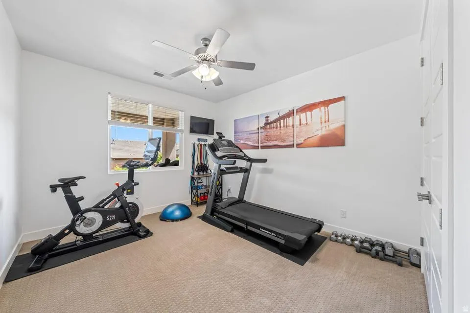 Exercise room with carpet and ceiling fan
