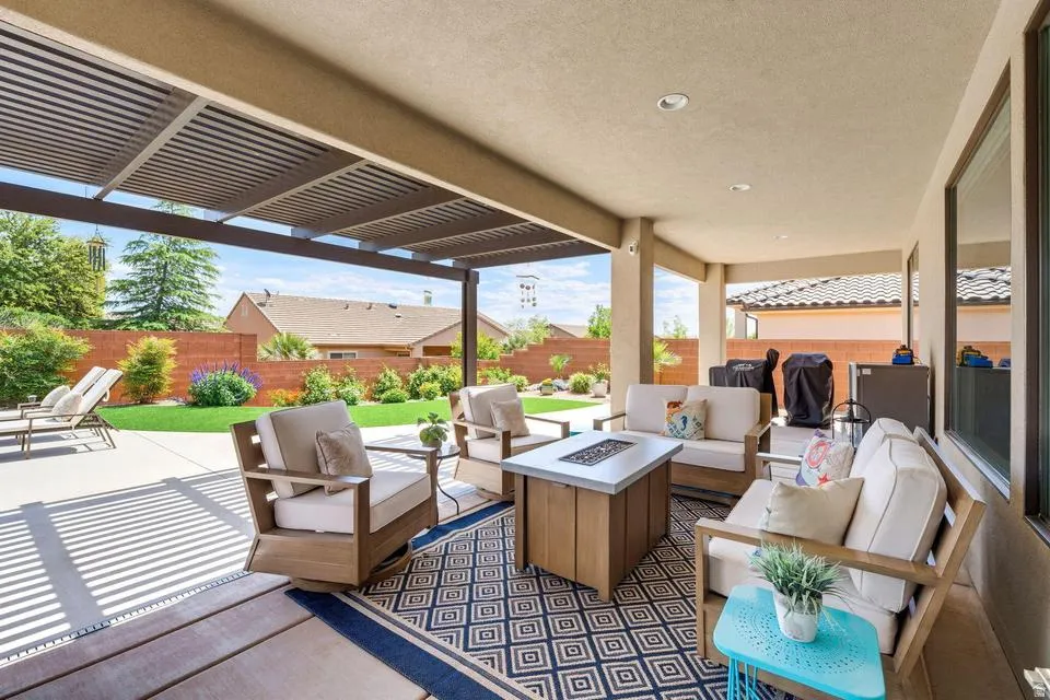 Fenced backyard with an outdoor living space with a fire pit, a patio area, a pergola, and grilling area