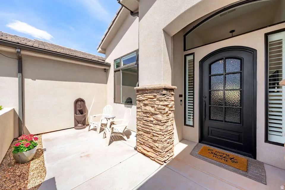 View of exterior entry with stucco siding and stone siding