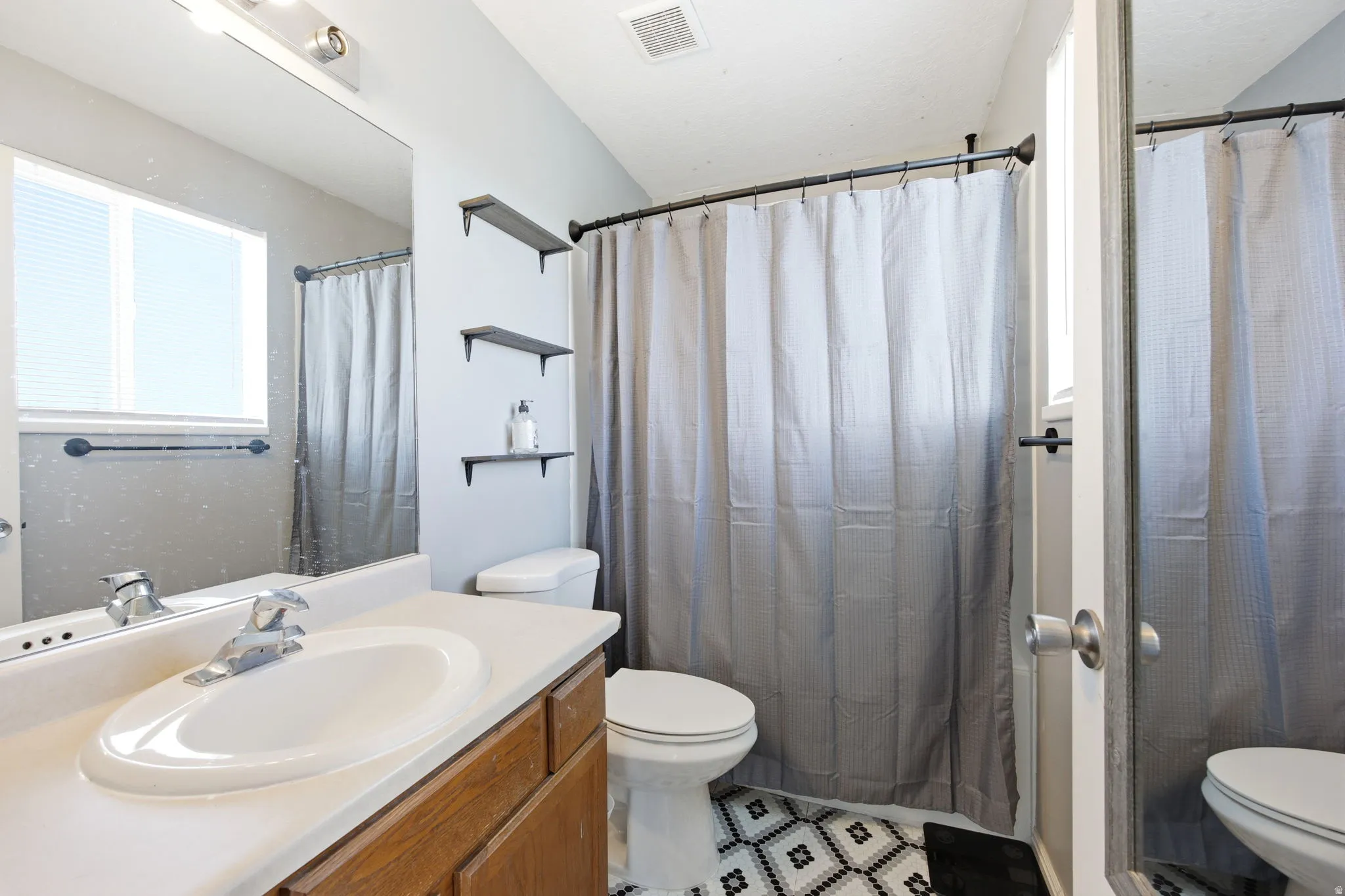 Bathroom with vanity and curtained shower