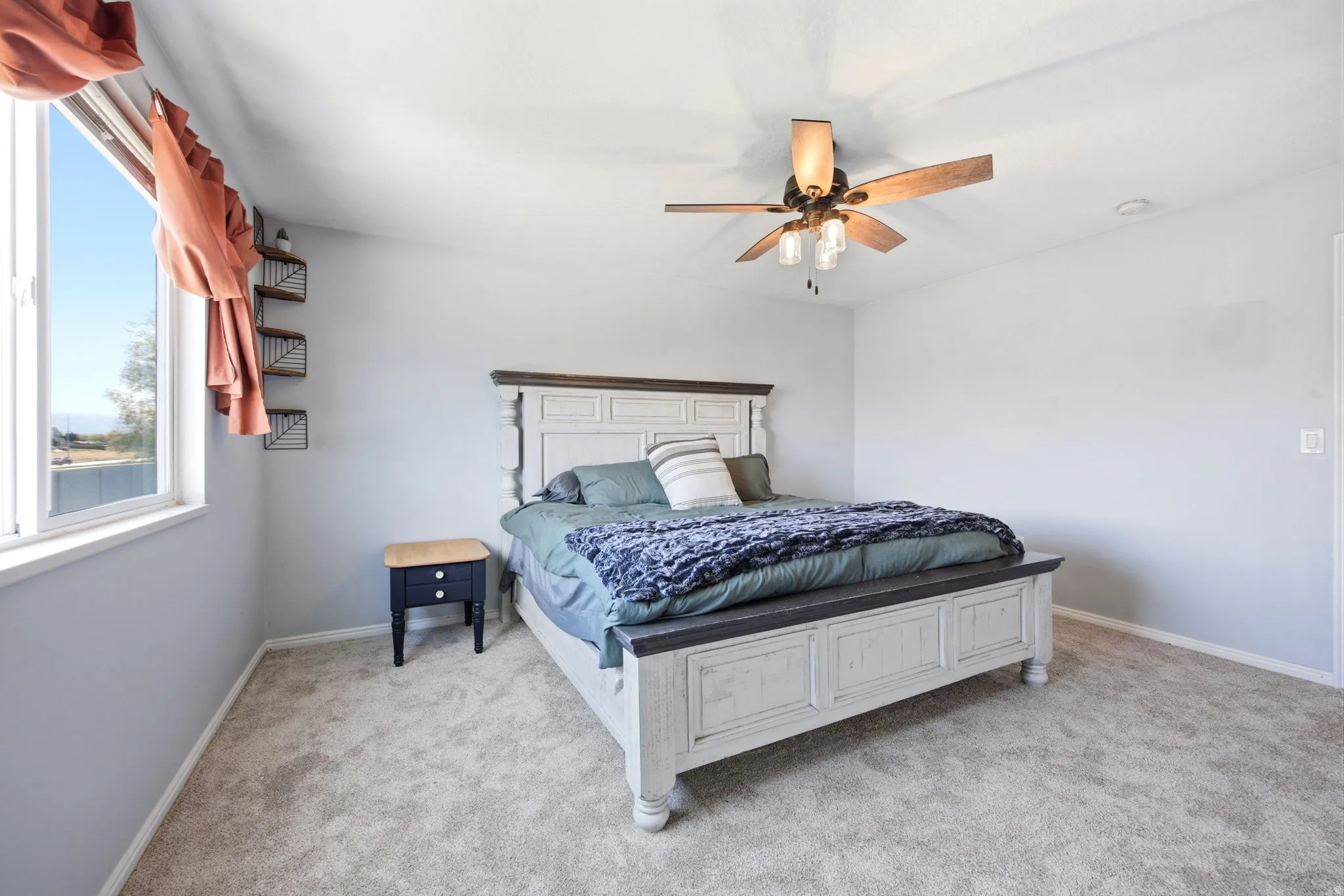 Bedroom with light carpet and a ceiling fan