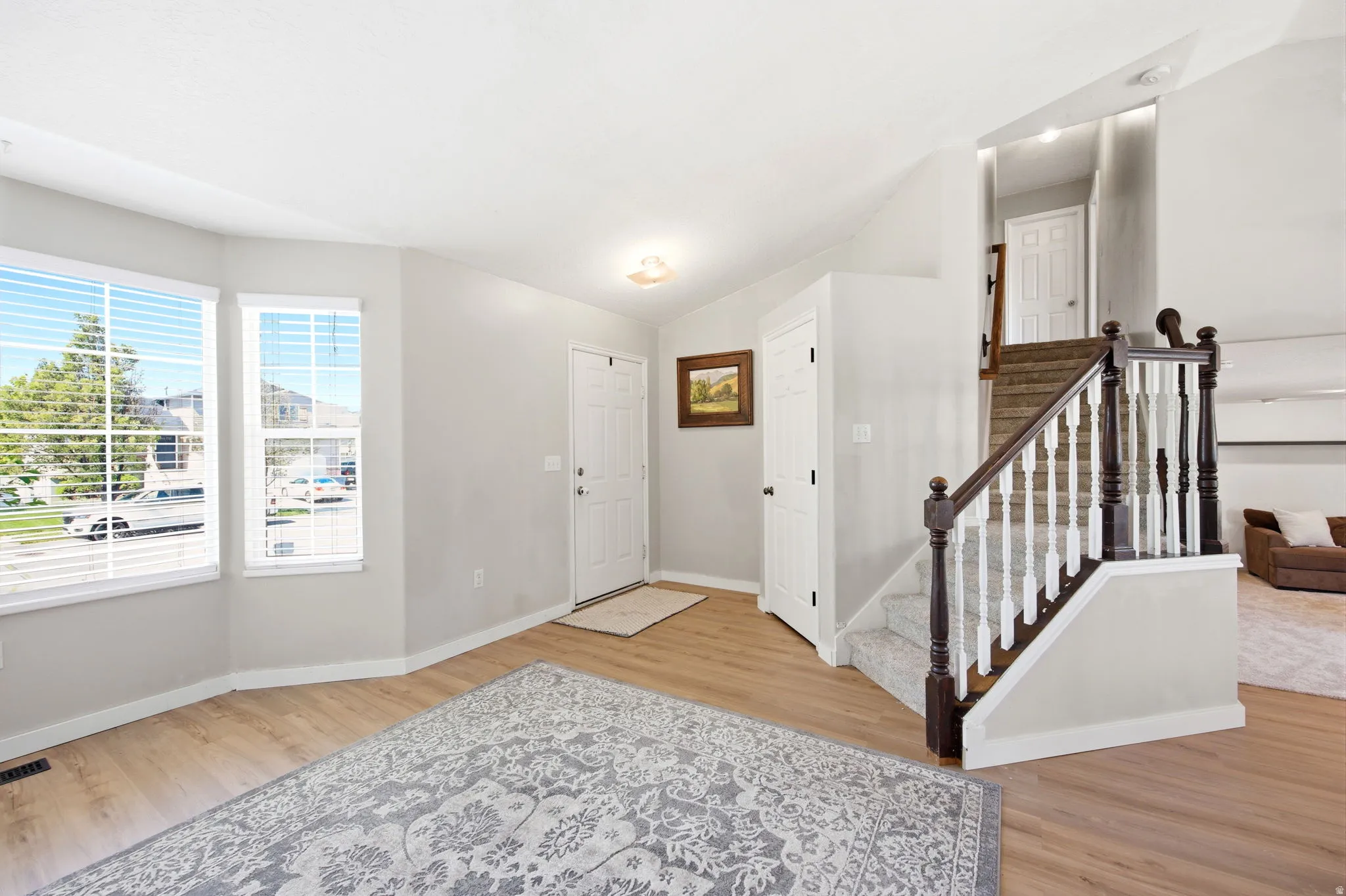 Entryway with light wood-type flooring and lofted ceiling
