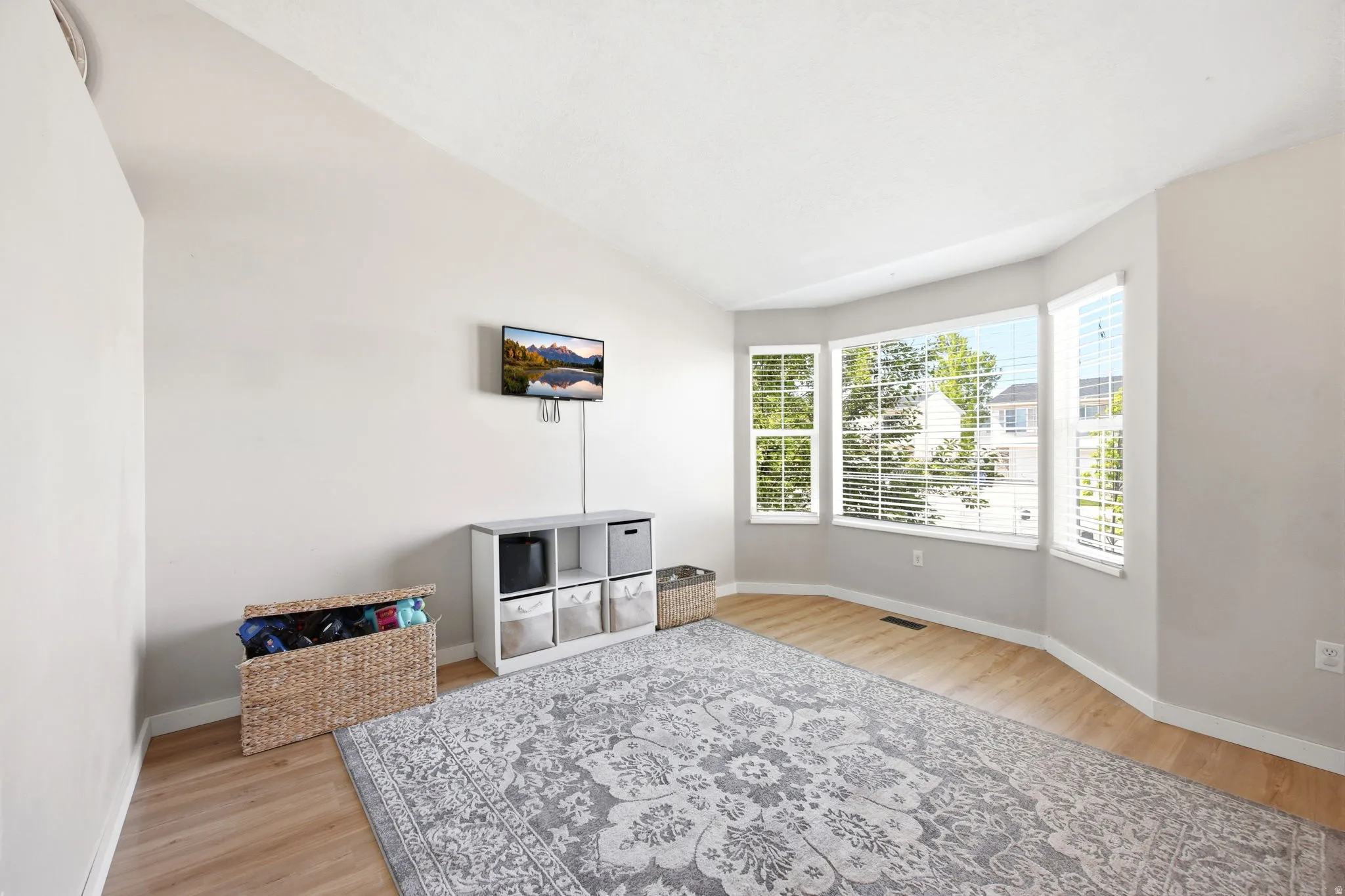 Living area featuring vaulted ceiling and light wood finished floors
