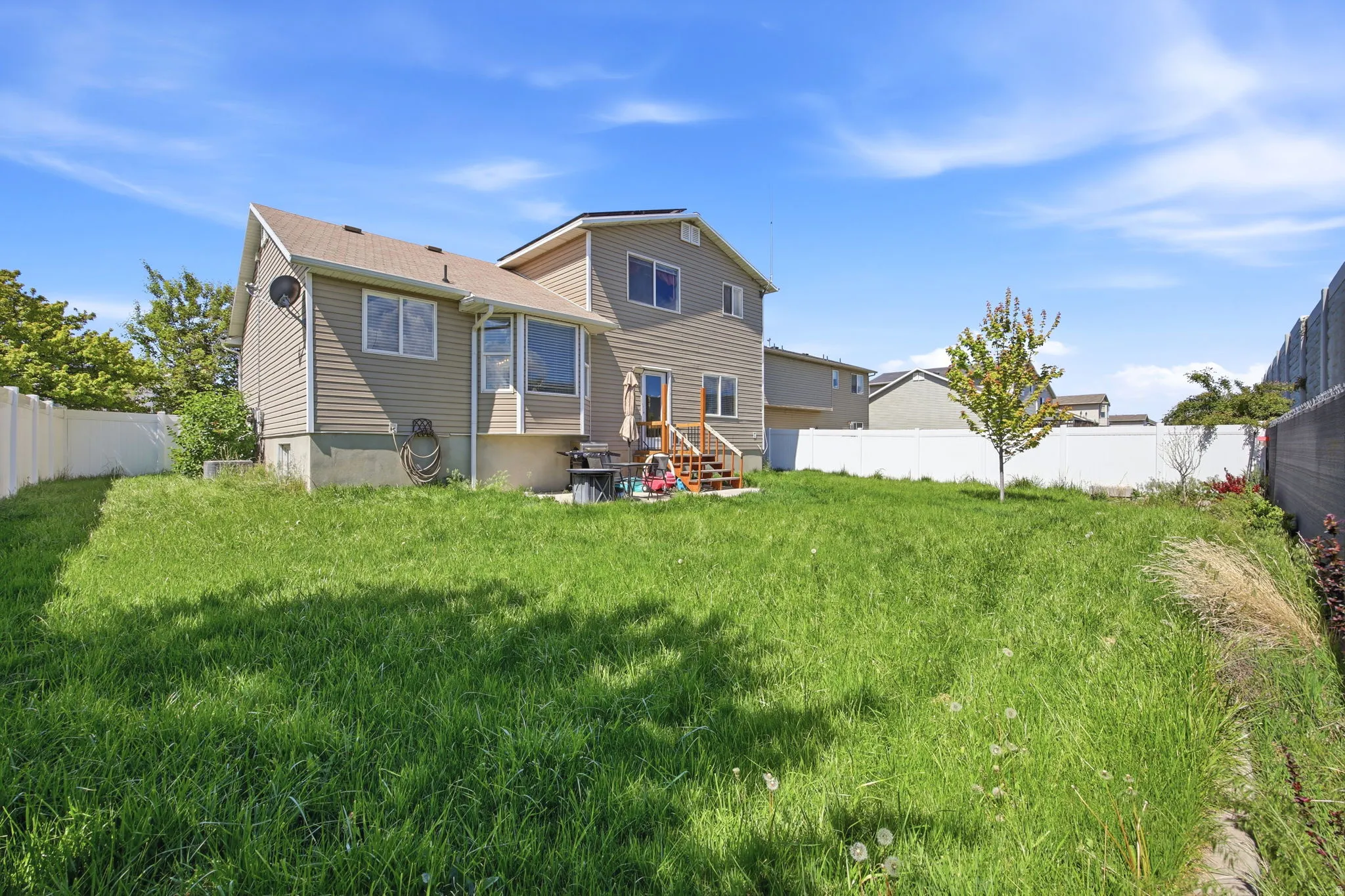 Rear view of house featuring a fenced backyard