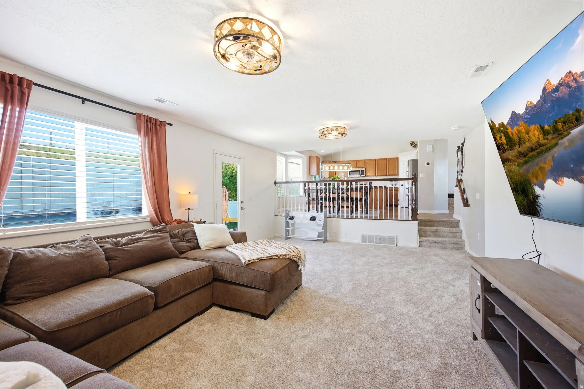 Living area featuring light carpet and stairs