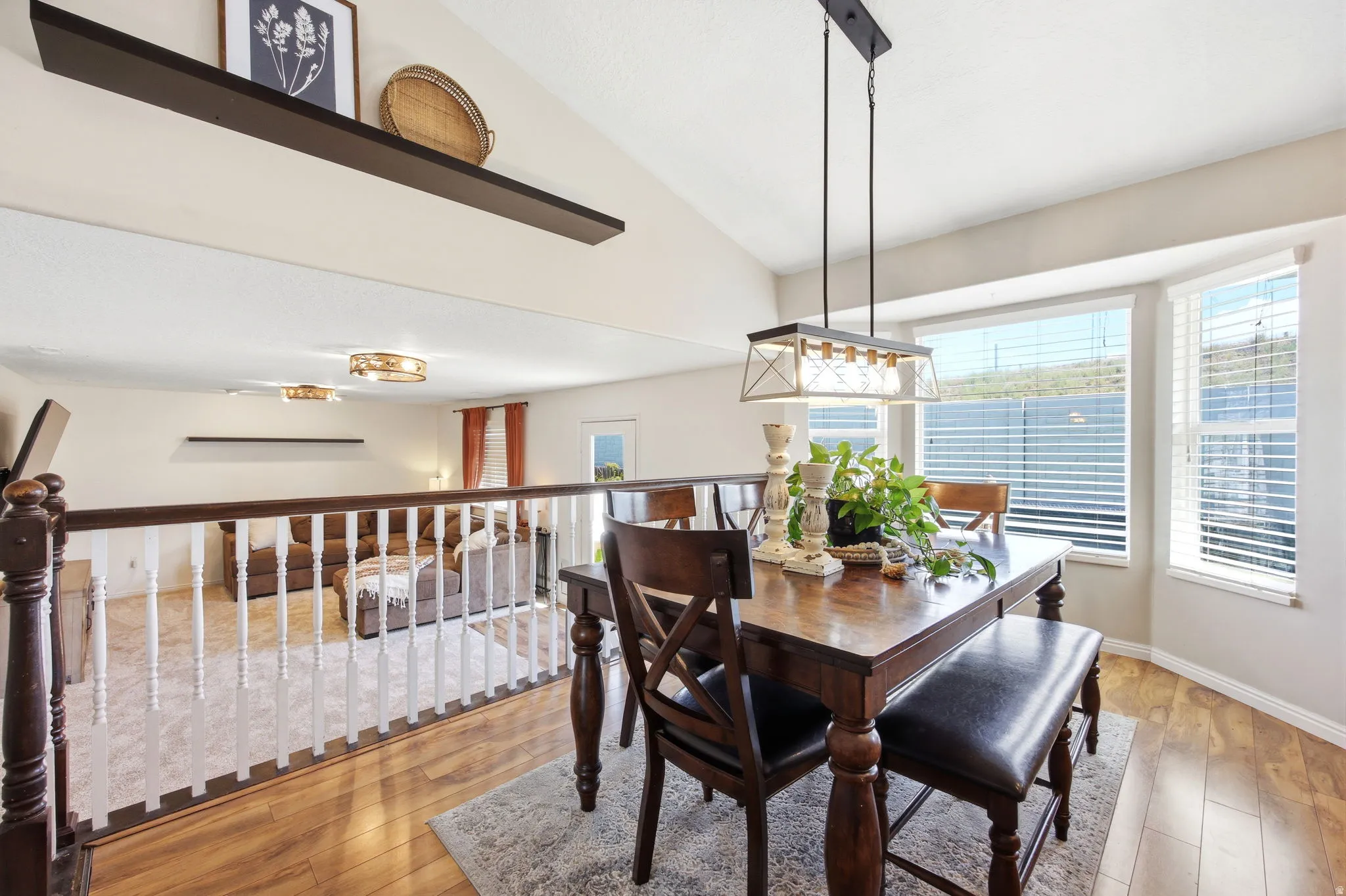 Dining room featuring light wood-type flooring and lofted ceiling
