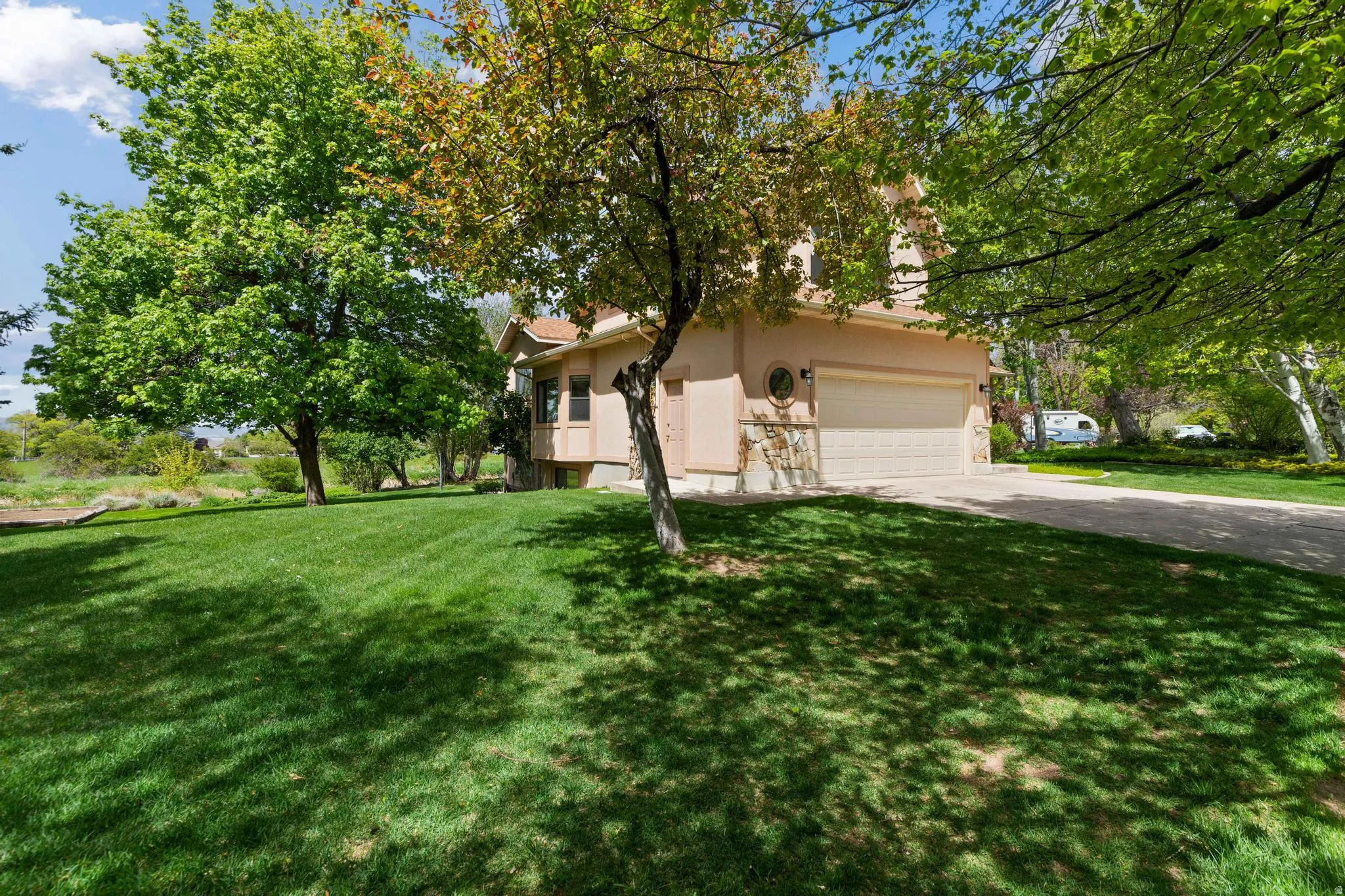 View of home's exterior featuring stucco siding, a yard, and driveway