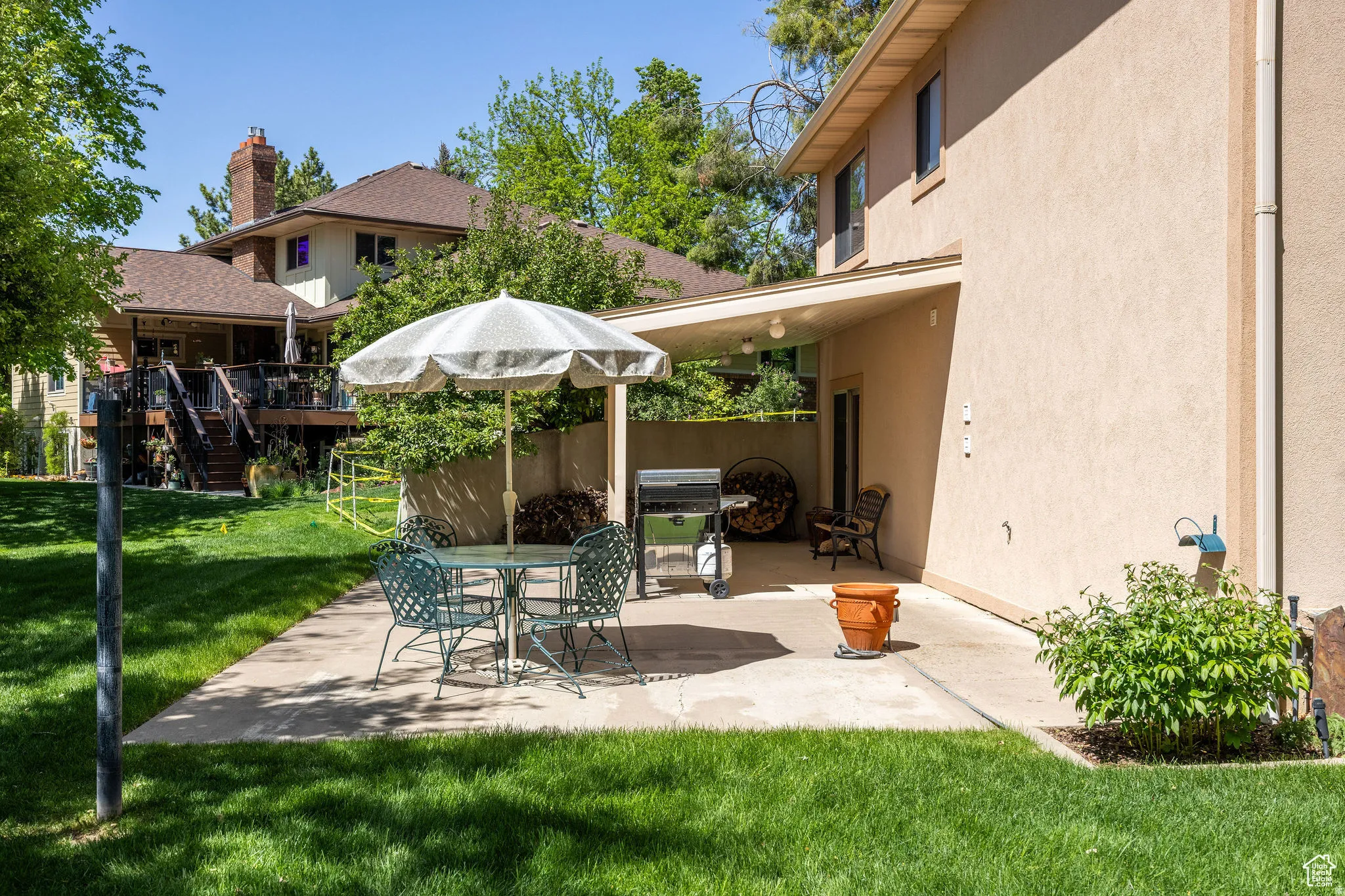 View of patio with area for grilling, a wooden deck, and outdoor dining area