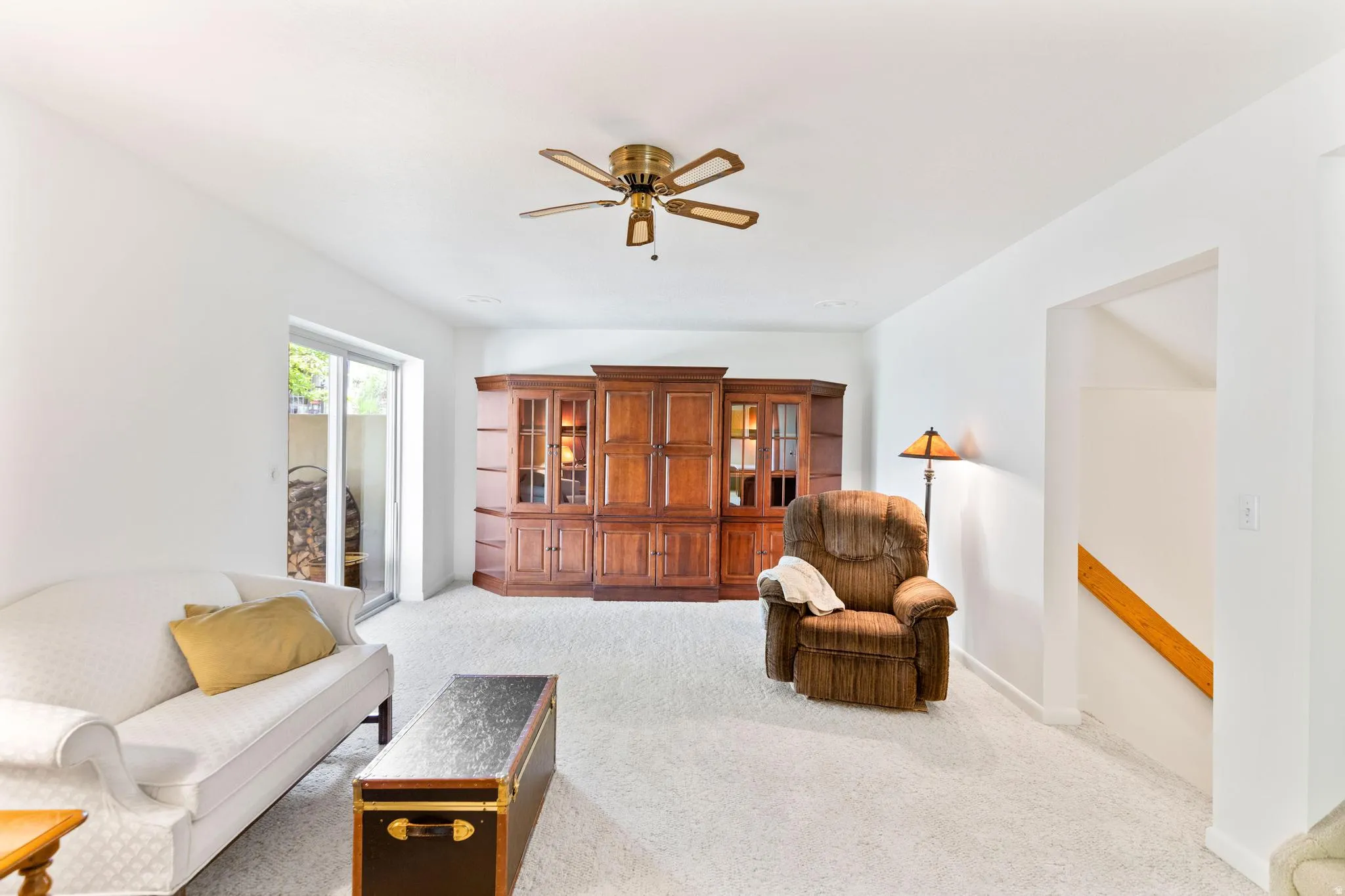 Living area featuring ceiling fan and light carpet