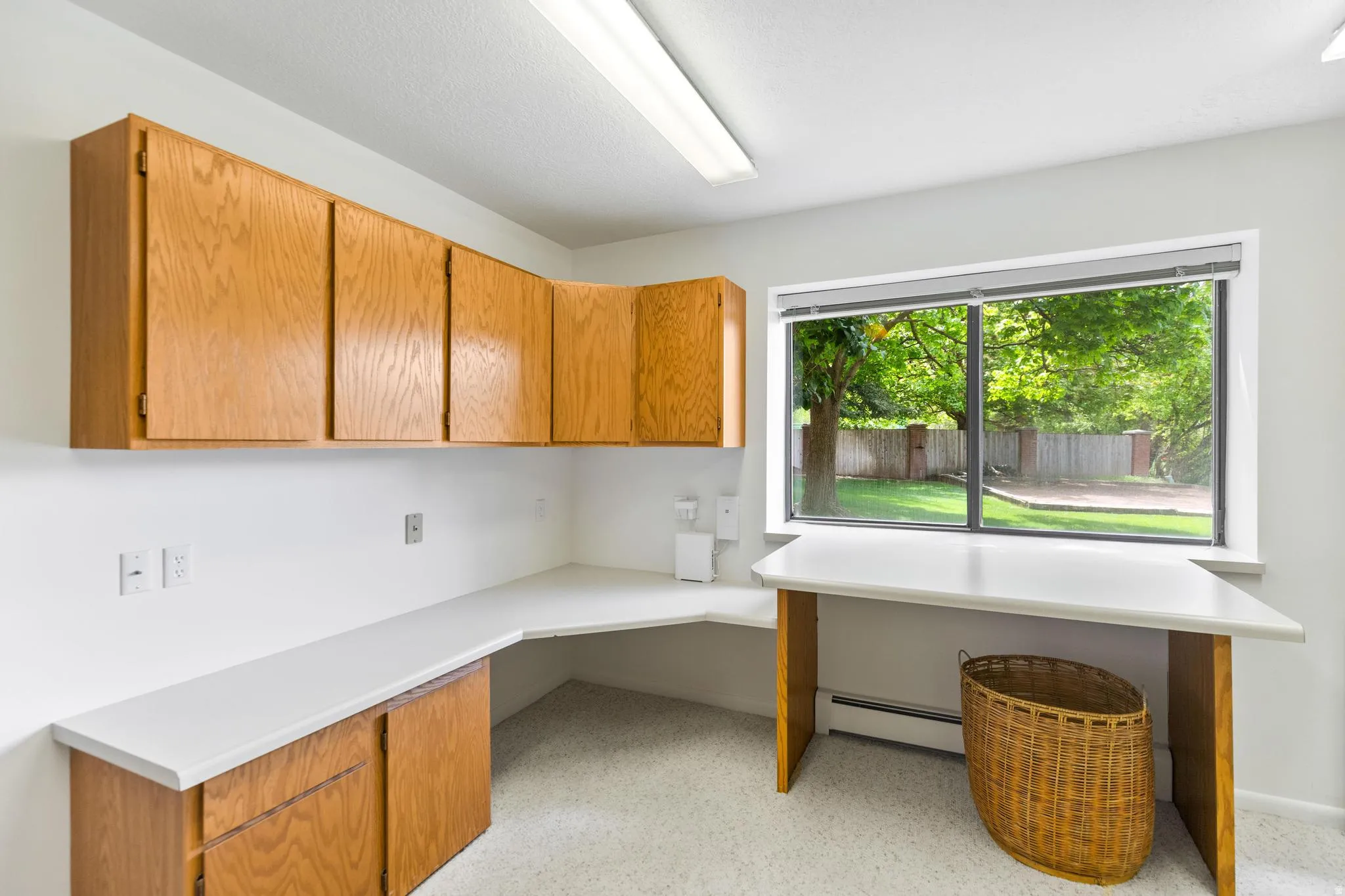 Unfurnished office featuring built in study area and baseboard heating