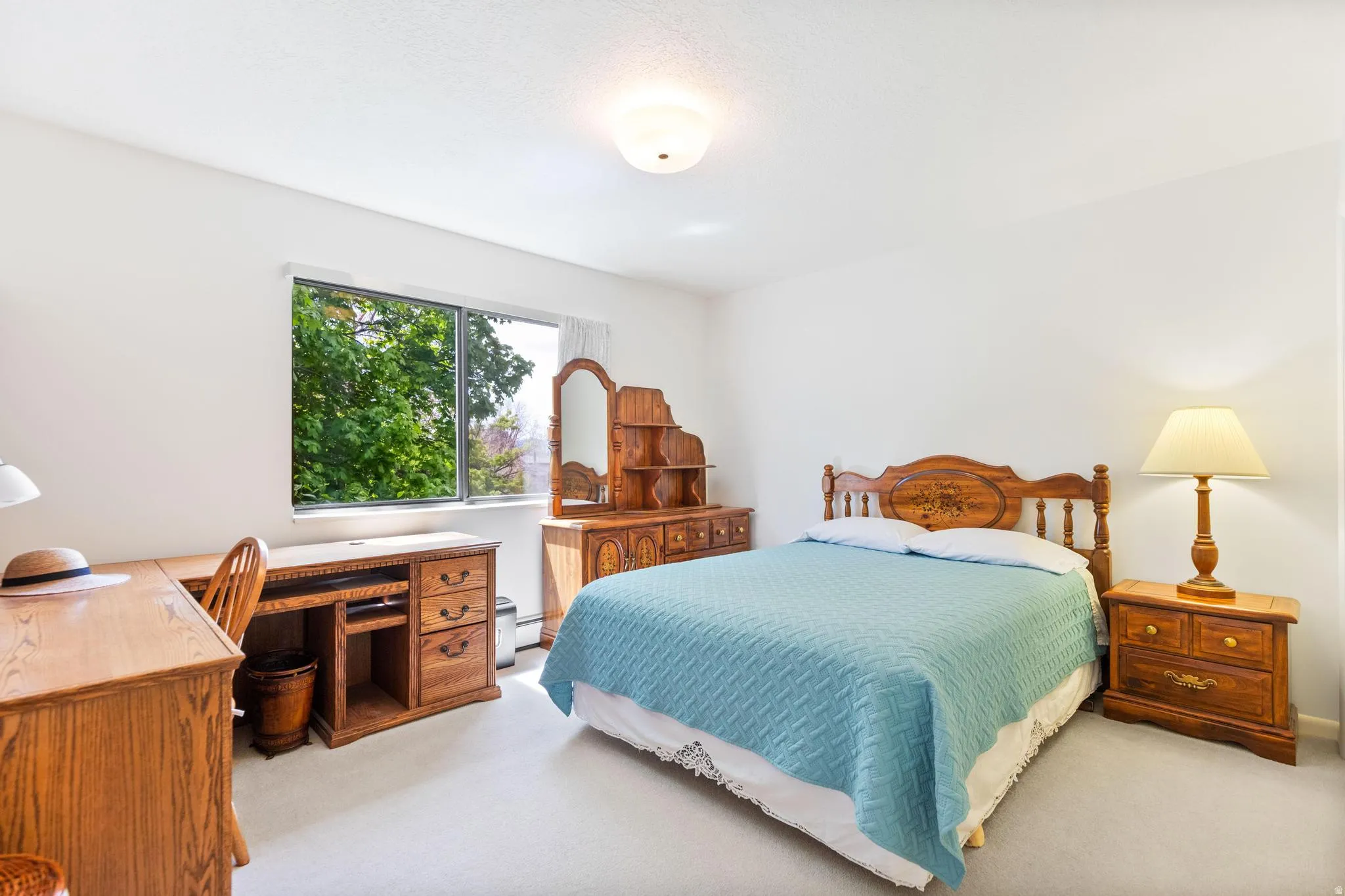 Bedroom with an office area and light carpet