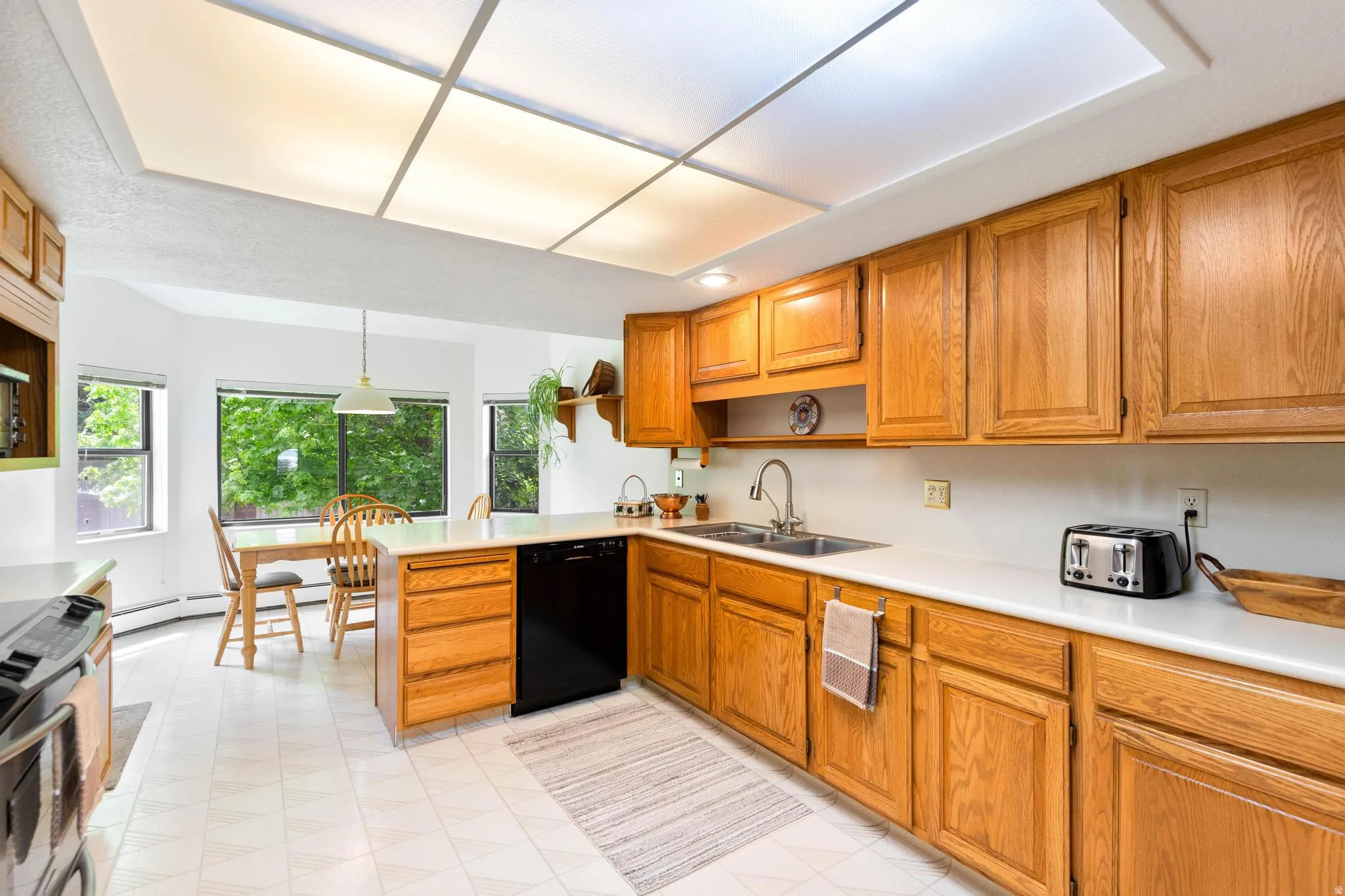 Kitchen with light countertops, wood finish cabinetry, and stainless steel range