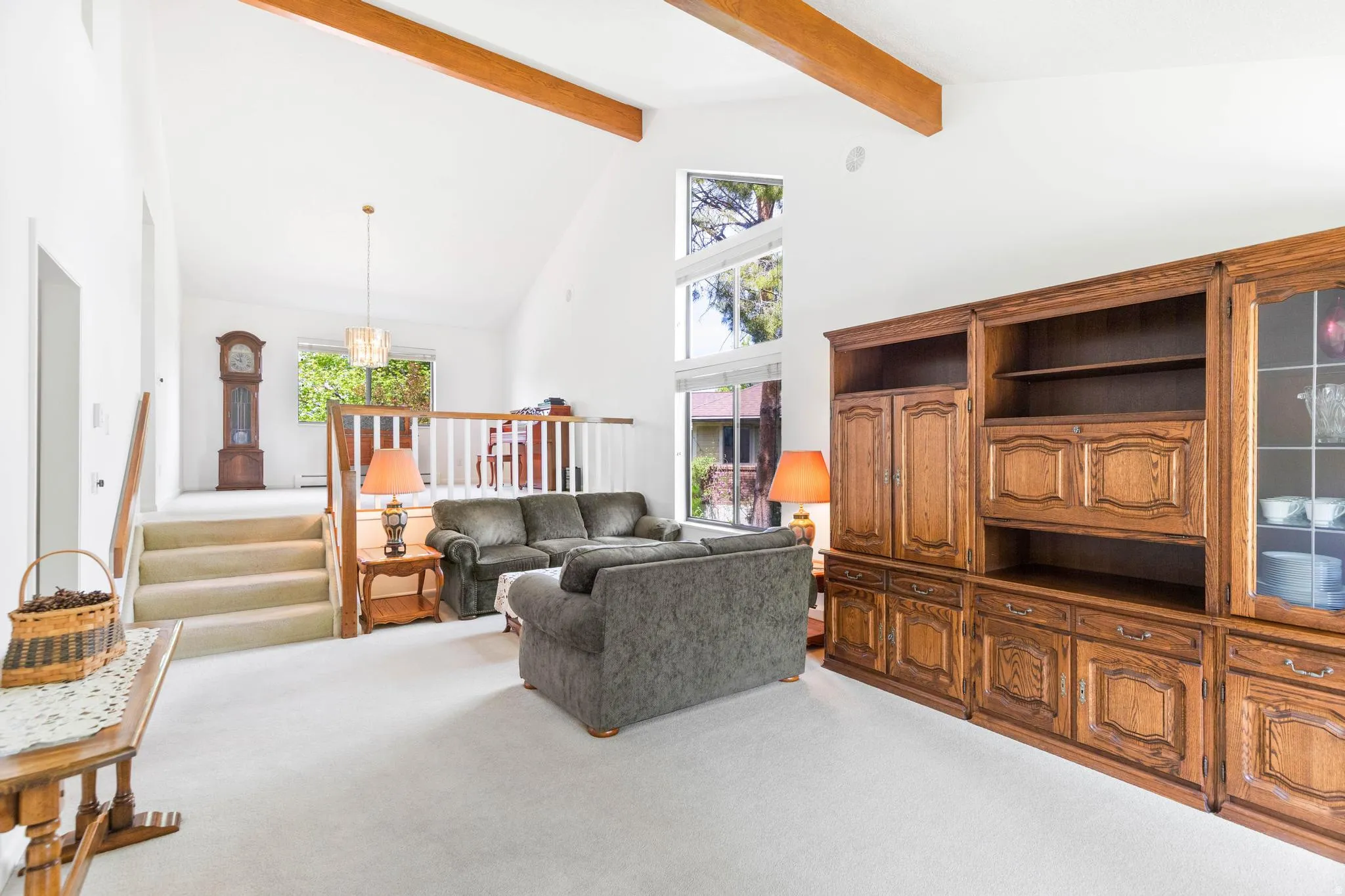 Living area with light colored carpet and stairs