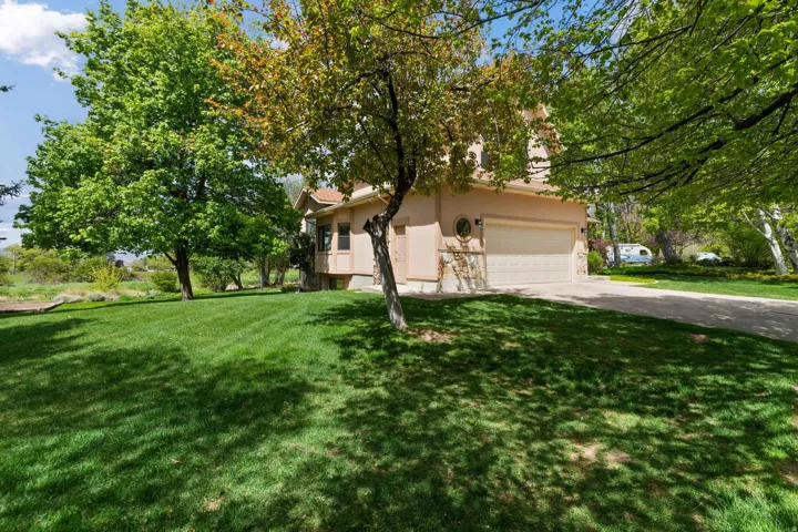 View of home's exterior featuring stucco siding, a yard, and driveway