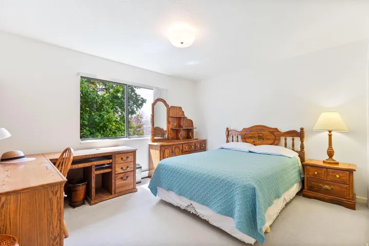 Bedroom with an office area and light carpet