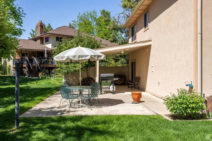 View of patio with area for grilling, a wooden deck, and outdoor dining area
