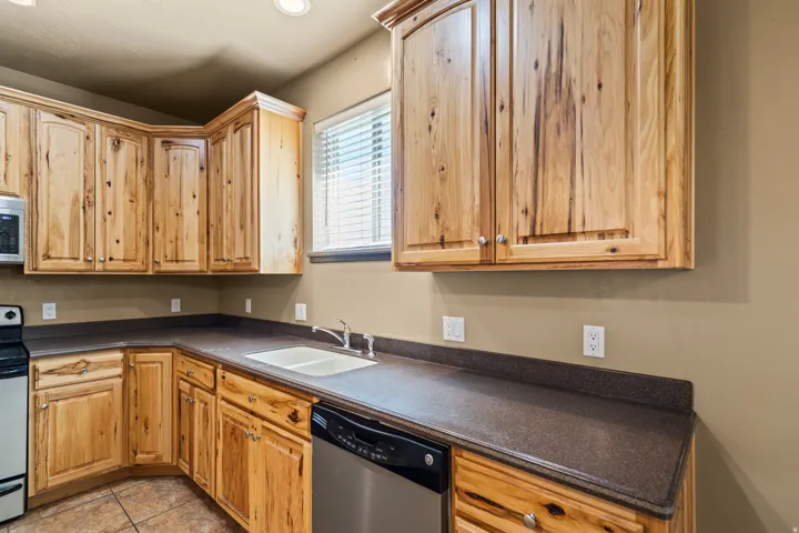 Kitchen with dark countertops, stainless steel appliances, and light tile patterned floors