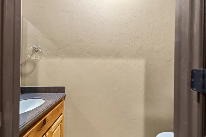 Bathroom featuring a textured wall, vanity, and a textured ceiling