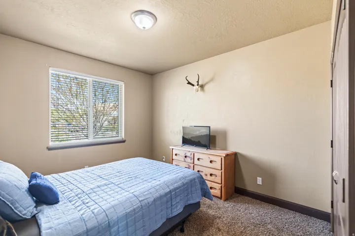 Bedroom with dark carpet and a textured ceiling