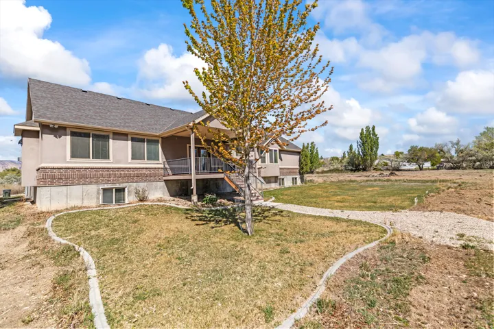 Rear view of property featuring a lawn and a shingled roof