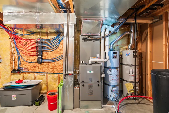 Utility room featuring strapped water heater