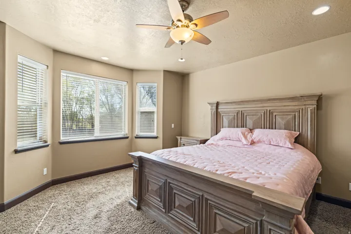 Carpeted bedroom featuring a ceiling fan, recessed lighting, and a textured ceiling