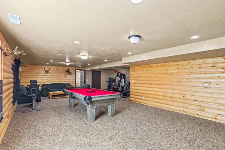 Game room with log walls, carpet flooring, billiards table, a textured ceiling, and recessed lighting