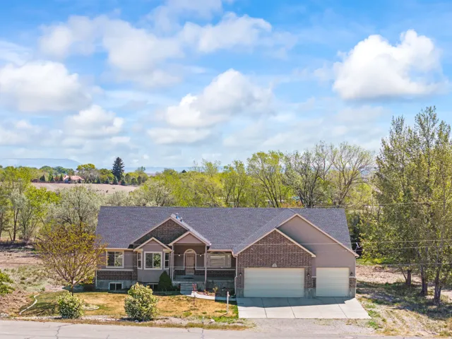 View of front of property featuring a porch, an attached garage, driveway, and a shingled roof