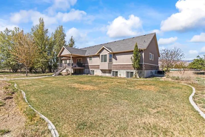 Back of property featuring a yard and roof with shingles