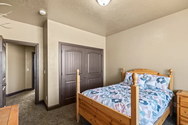 Bedroom featuring dark colored carpet, a textured ceiling, and a closet
