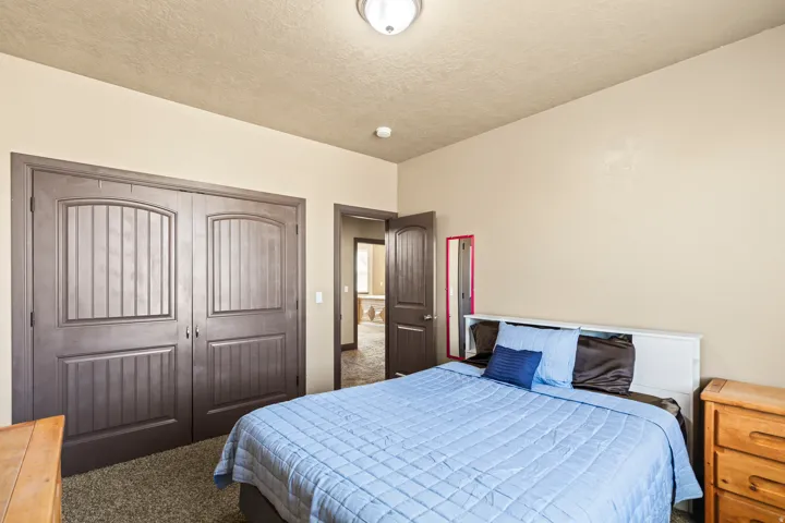 Bedroom with carpet flooring, a closet, and a textured ceiling