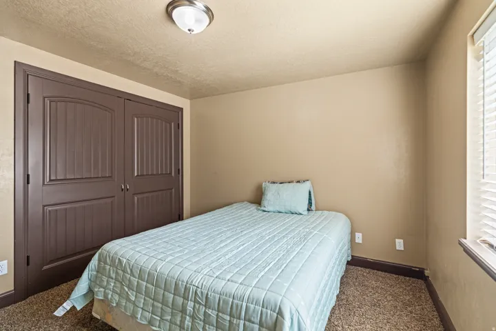 Bedroom featuring dark carpet, a closet, and a textured ceiling