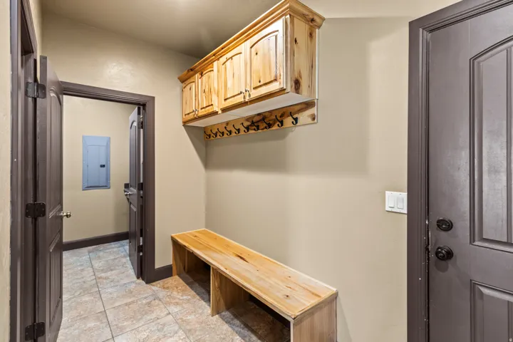 Mudroom with electric panel and baseboards