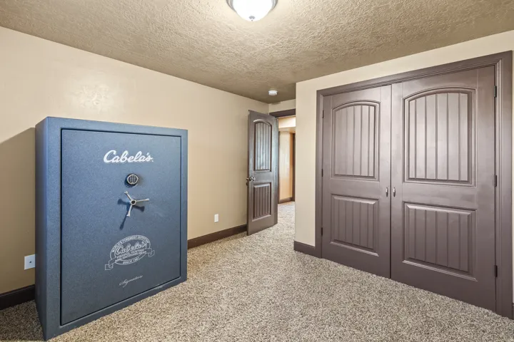 Unfurnished bedroom with light carpet, a textured ceiling, and a closet