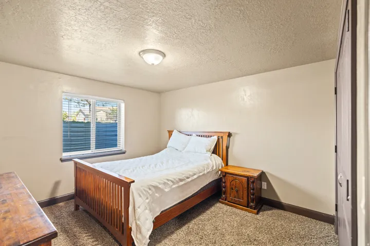 Bedroom featuring a textured ceiling and dark colored carpet