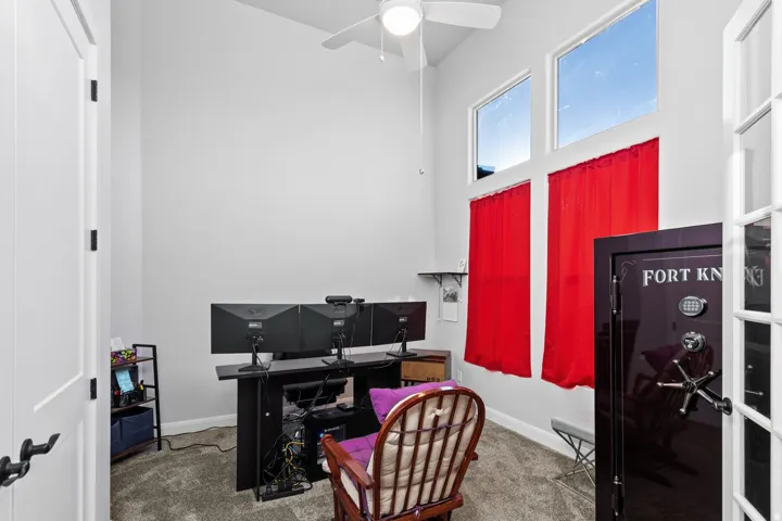 Office with light colored carpet and a ceiling fan