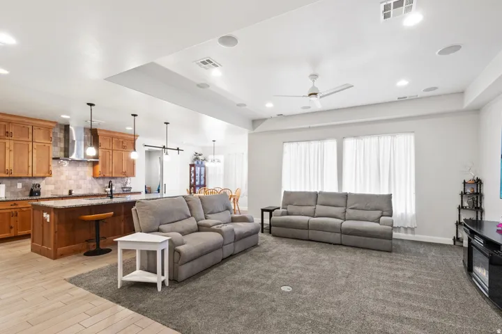 Living area with a ceiling fan, recessed lighting, and light wood-style flooring