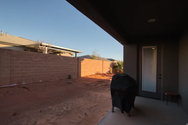 Fenced backyard with a patio and grilling area