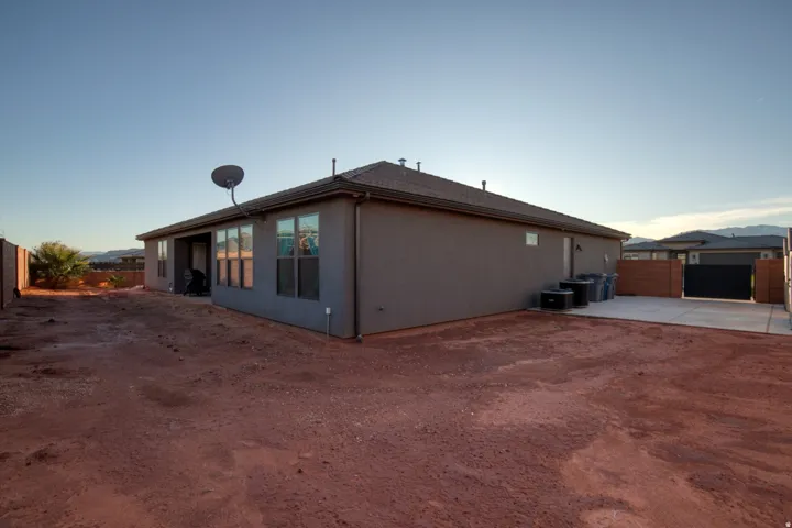 Back of house at dusk featuring a fenced backyard