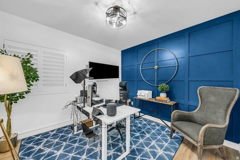 Office featuring a decorative wall and wood finished floors