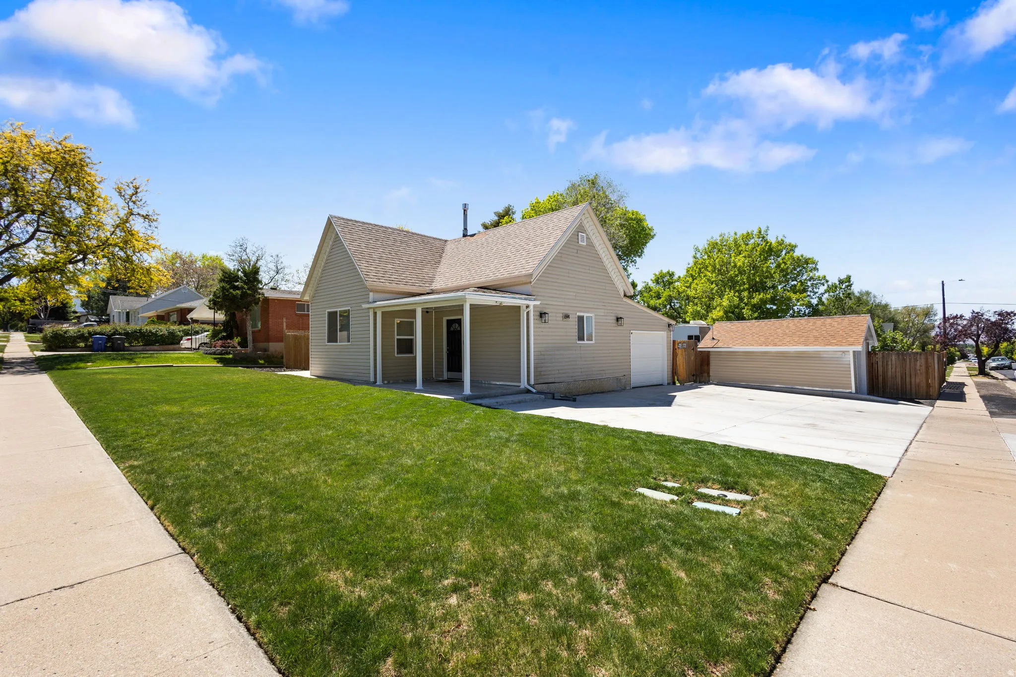 View of front of home featuring covered porch, concrete driveway, and a shingled roof