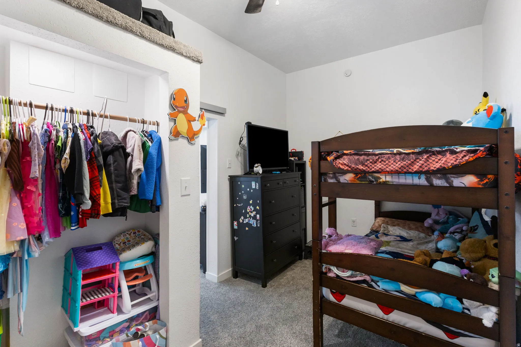 Bedroom with light colored carpet, a ceiling fan, and a closet