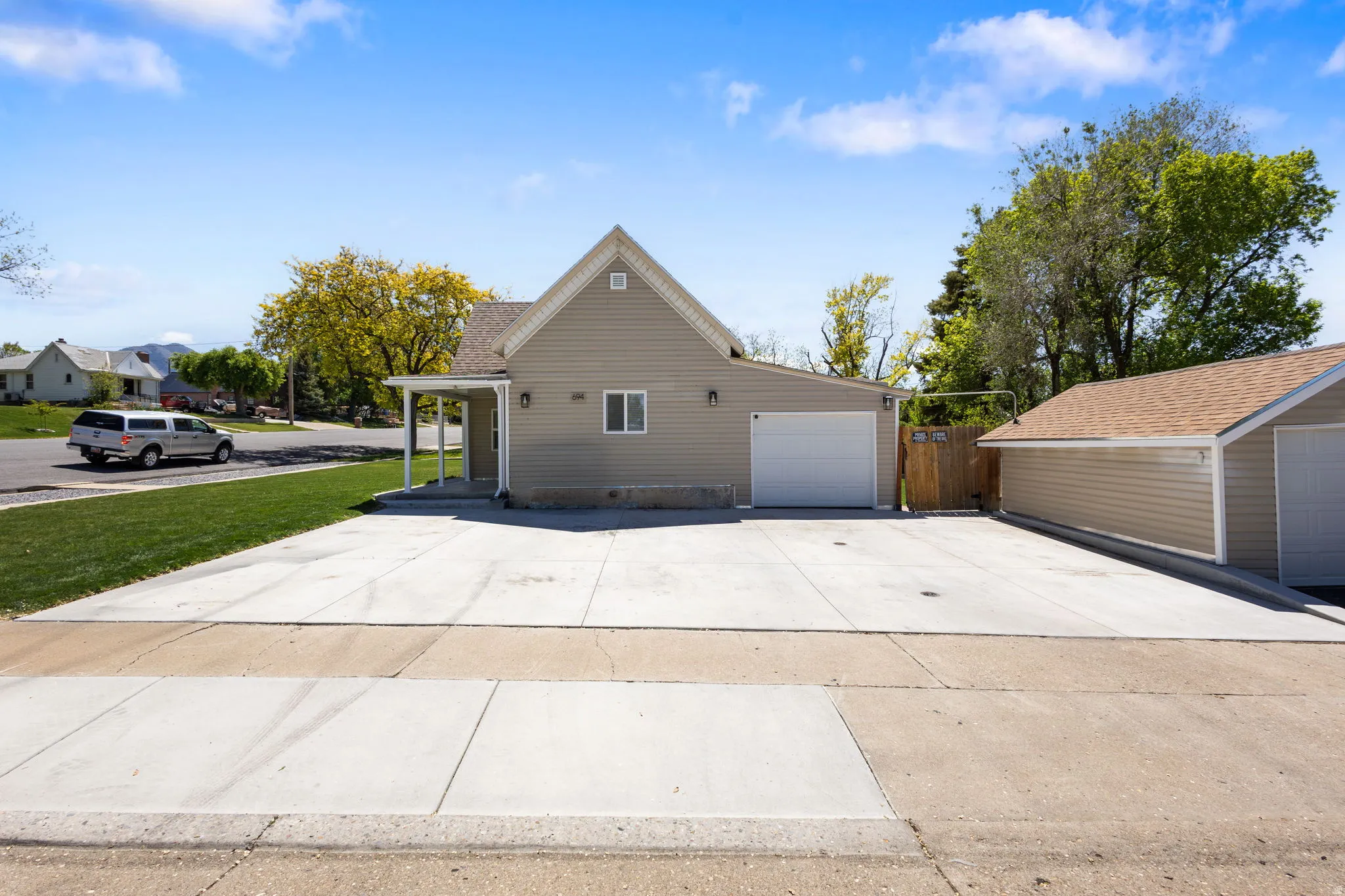 View of property exterior with driveway, a lawn, and a garage