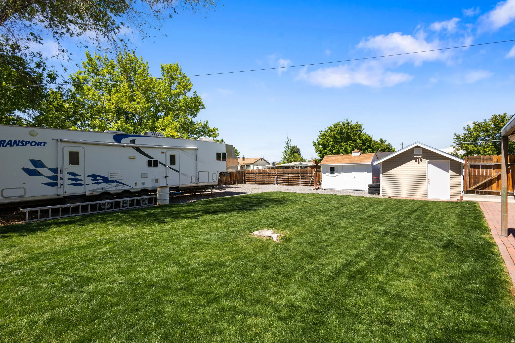 Fenced backyard with a storage shed